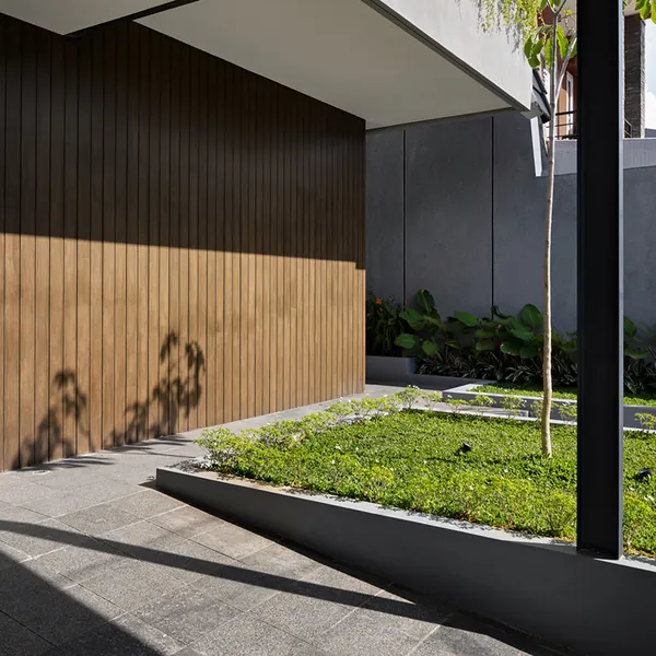 Timber-slat wall and garden courtyard in afternoon shadow